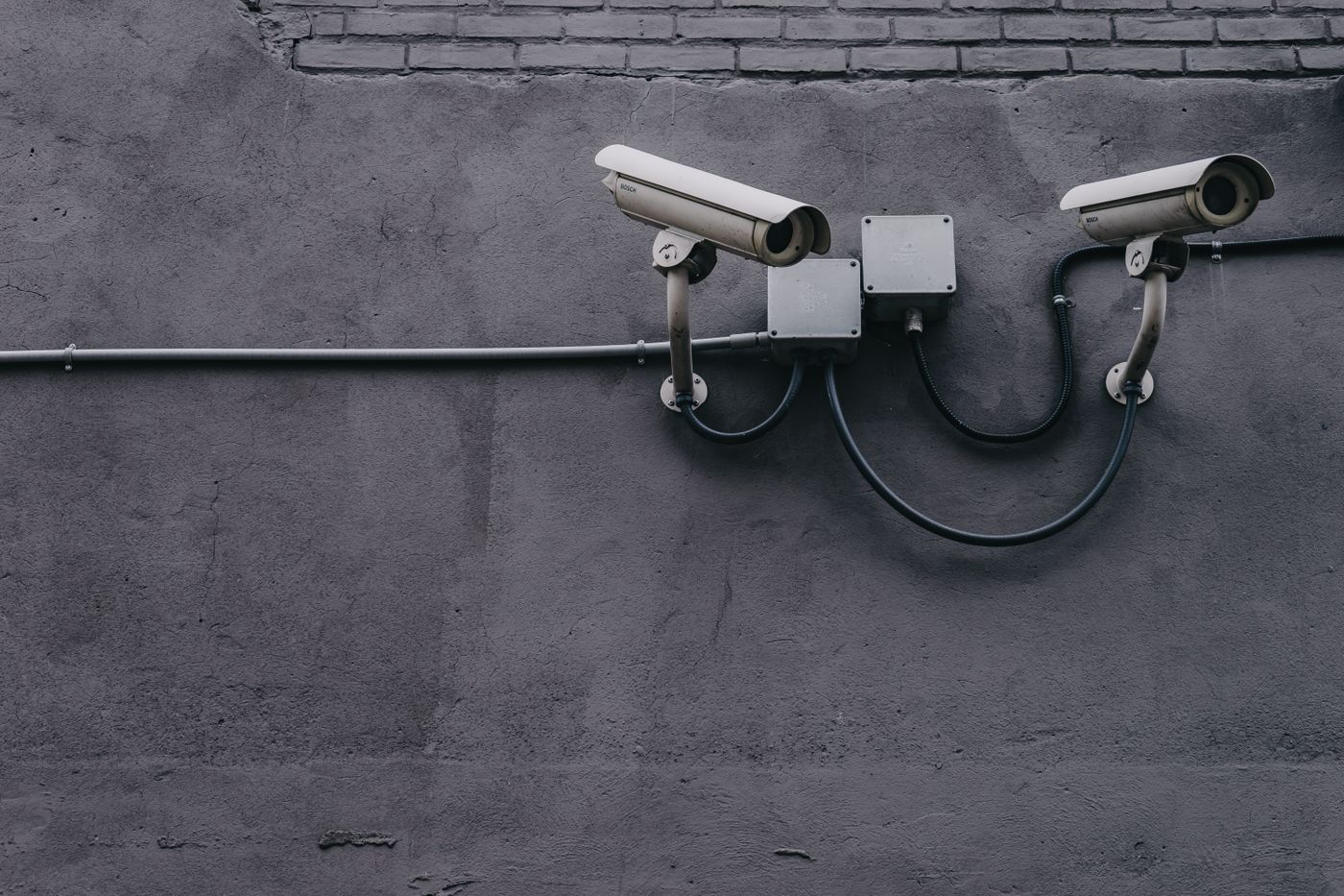 Two grey outdoor bullet CCTV cameras