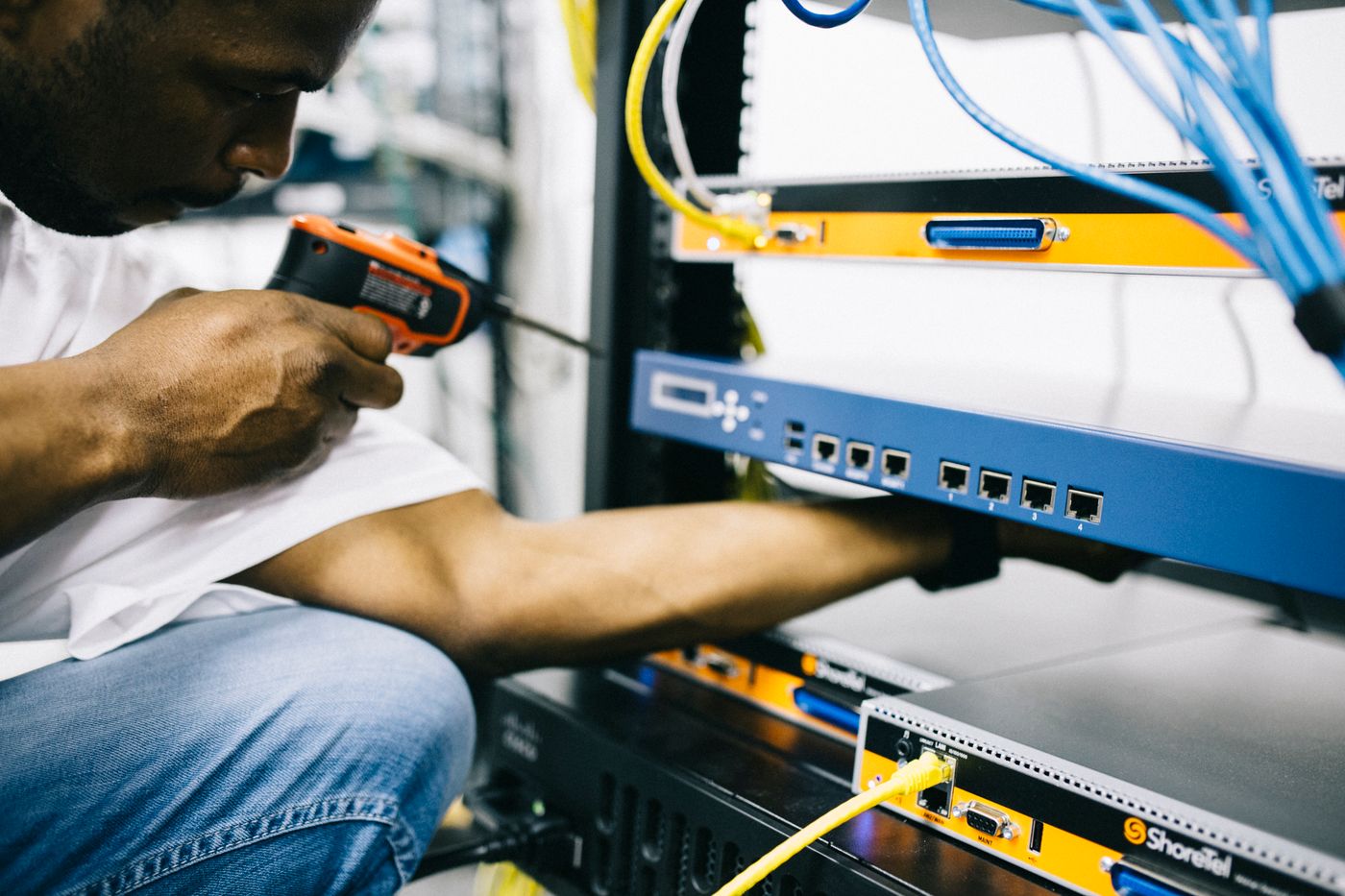 A CCTV technician fitting a camera with a screw gun
